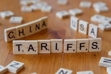 Scrabble tiles spelling out Tariffs, China, and USA, highlighting trade tensions
